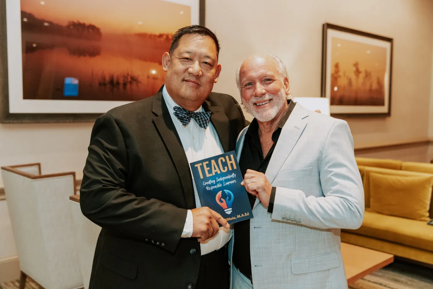 FPEA Treasurer Larry Wang and Dennis DiNoia holding Dennis&rsquo;s book TEACH