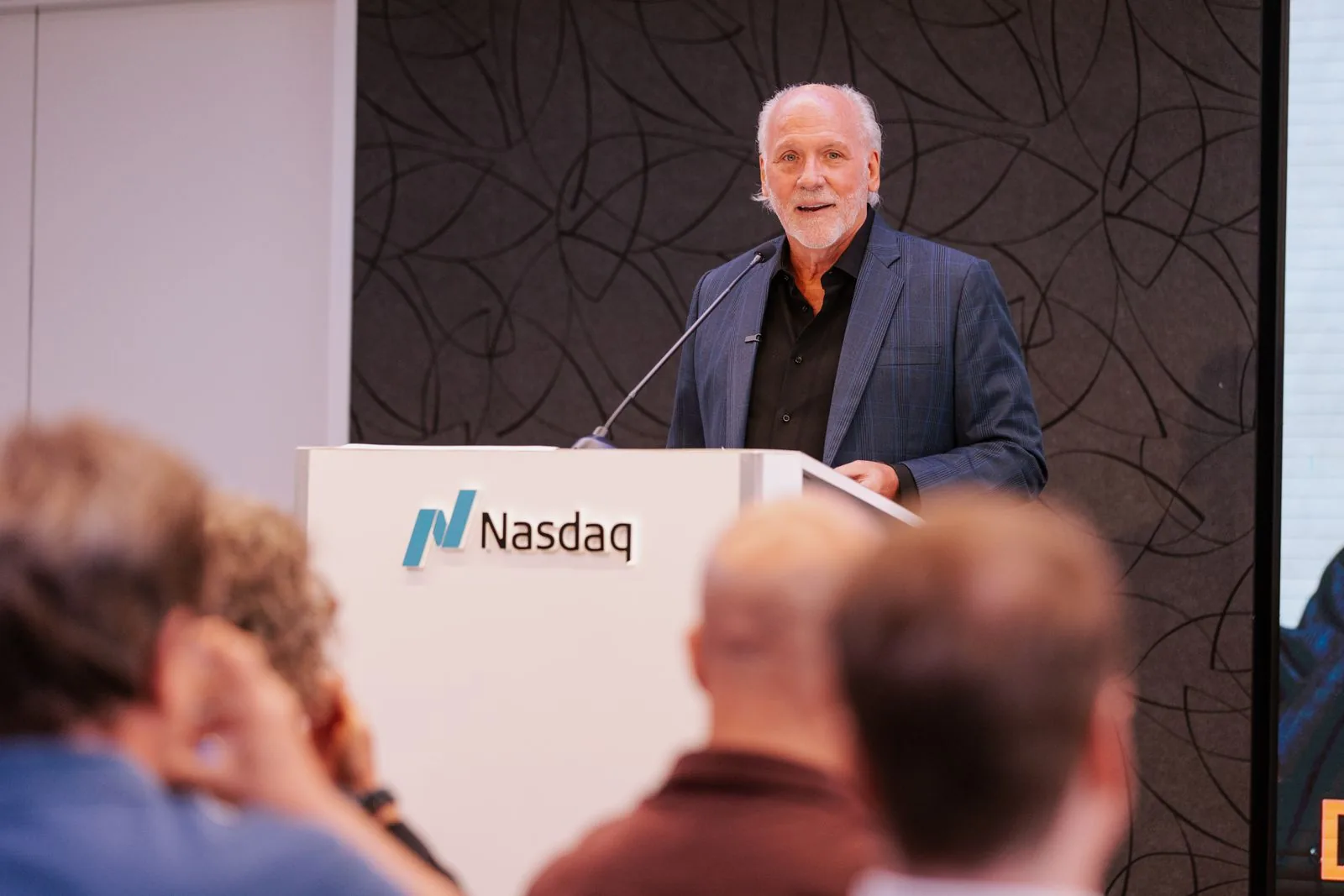 Dennis speaking from the Nasdaq podium in New York